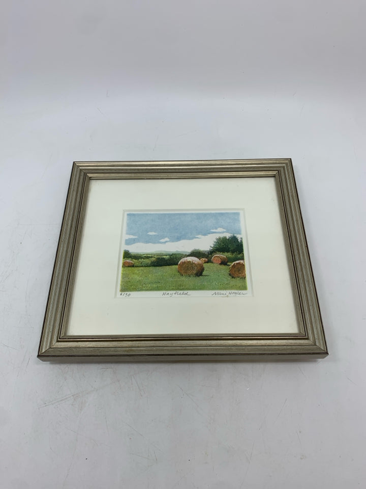 PAINTED FIELD W/HAY BALES IN SILVER FRAME.