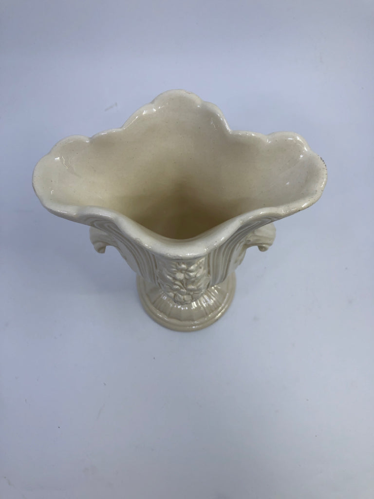 CREAM CERAMIC FOOTED VASE W/FLOWER DETAIL.