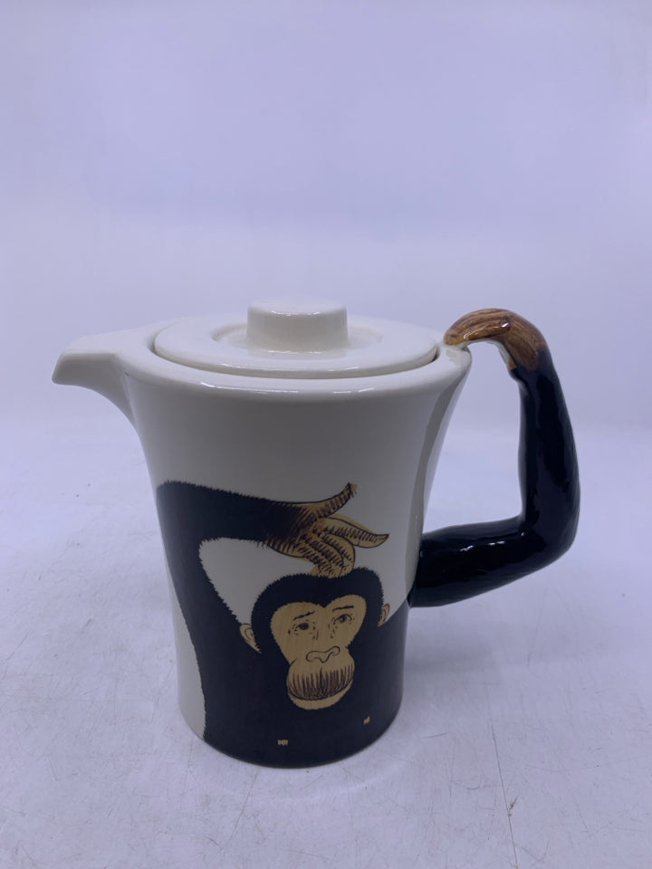 CREAM W/ MONKEY ON IT AND ARM AS HANDLE.
