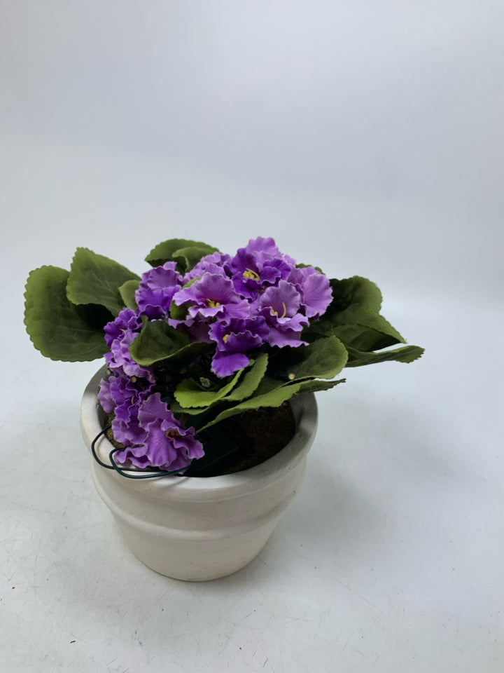 CREAM PLANTER W/ FAUX PURPLE FLOWERS AND LIGHTS.