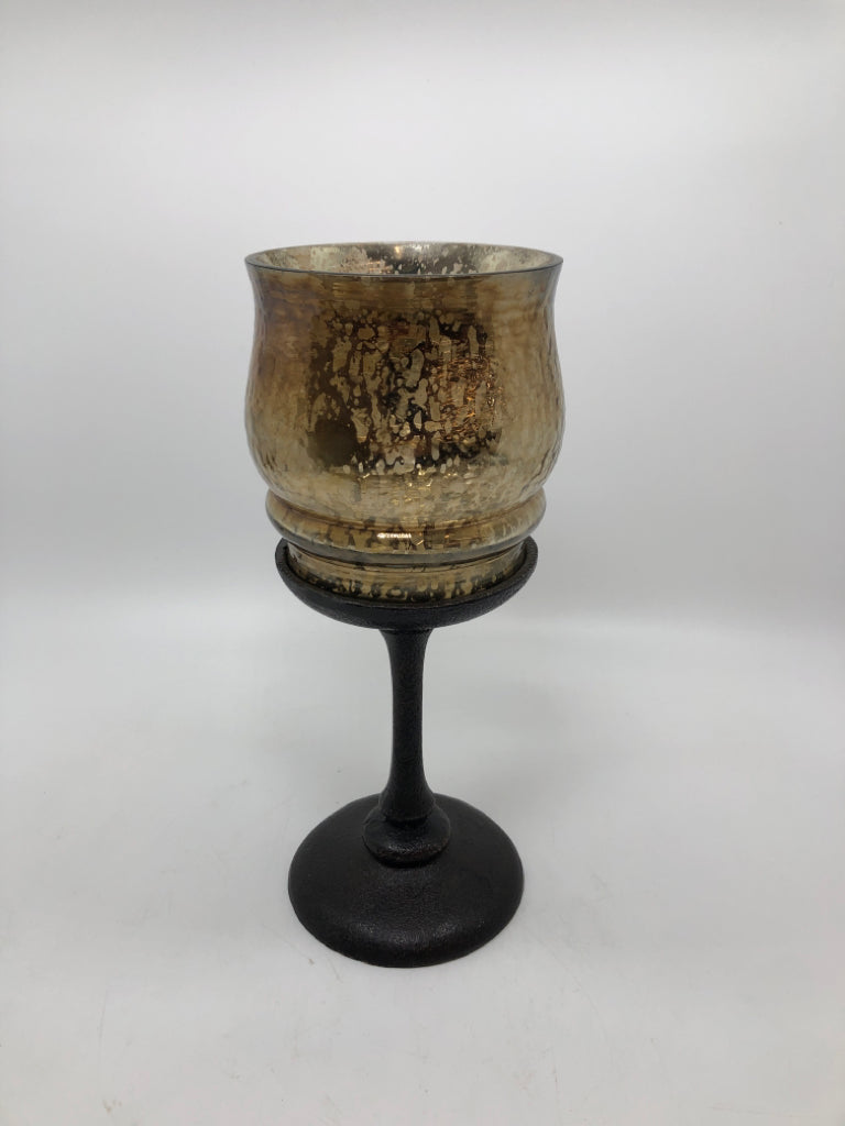 GOLD MERCURY GLASS CANDLE HOLDER ON BROWN METAL BASE.