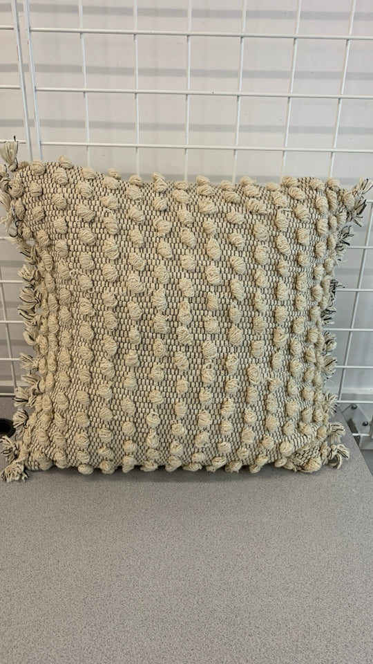 TAN ACCENT PILLOW W/KNIT BALLS AND TASSELS.