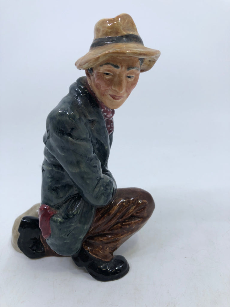 VTG "THE POACHER" KNEELING MAN WITH BLUE COAT AND TAN HAT.