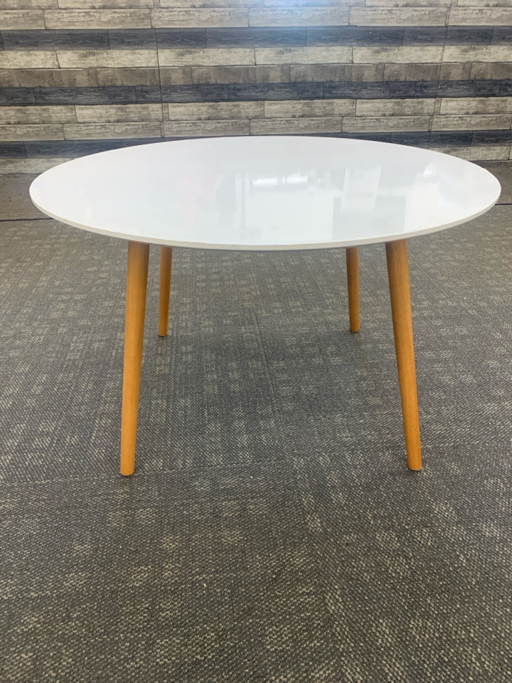 ROUND WHITE COFFEE TABLE W/WOOD LEGS.