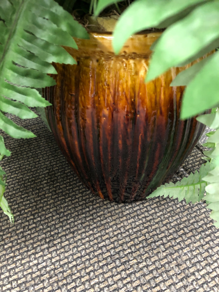 FAUX FERN IN BROWN CERAMIC PLANTER.