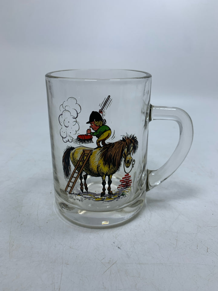 CLEAR GLASS MUG W/ PRINTED MAN ON HORSE BRUSHING IT OFF.