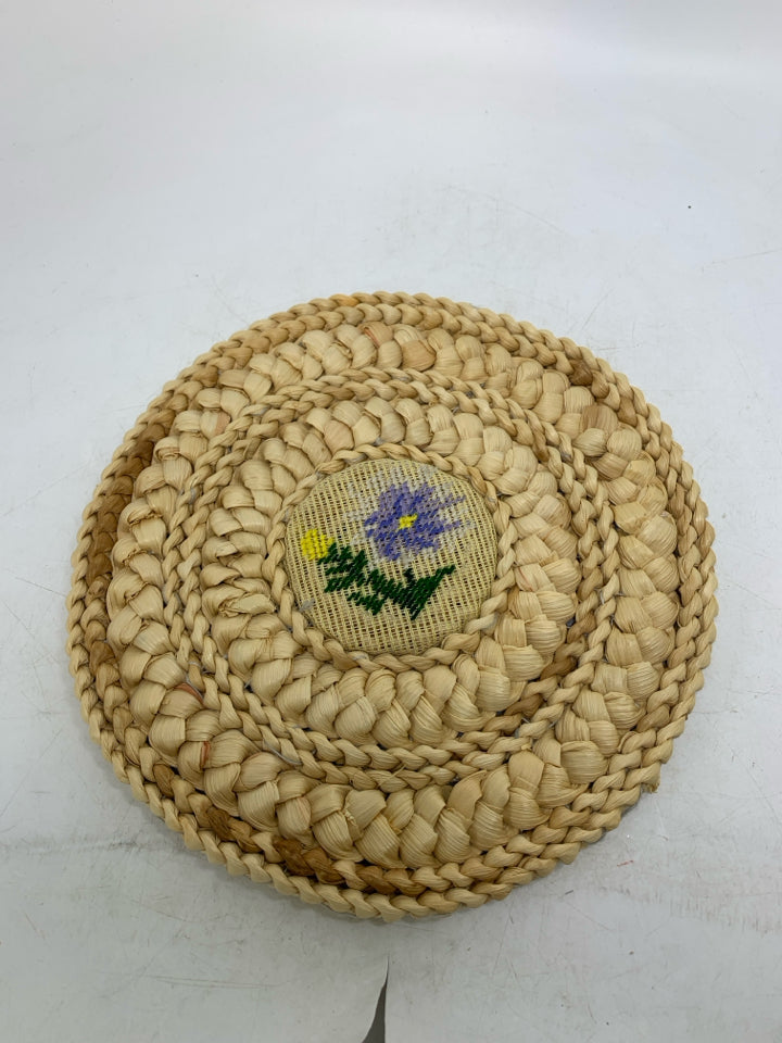 VTG BLONDE WOVEN CIRCLE TRIVET W/ NEEDLE POINT FLORAL CENTER.