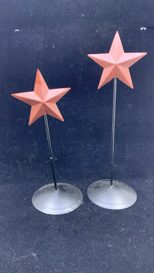 2 MAROON METAL STARS ON BLACK STANDS.