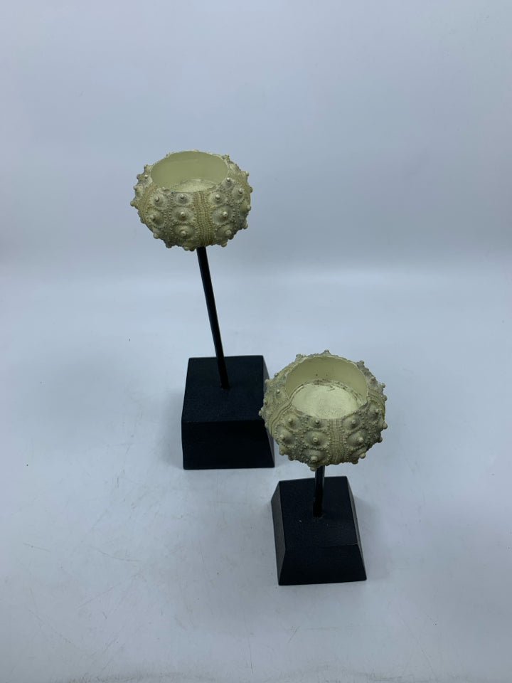 2 SHELL LOOK TEA LIGHT HOLDERS ON BLACK STANDS.