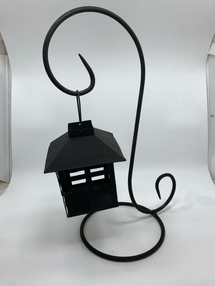 BLACK METAL LANTERN ON SCROLL STAND.
