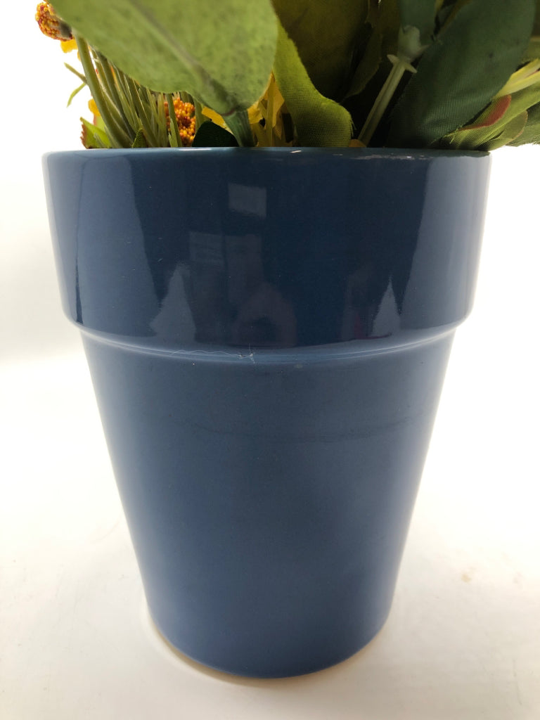 YELLOW FAUX FLOWERS IN BLUE PLANTER.
