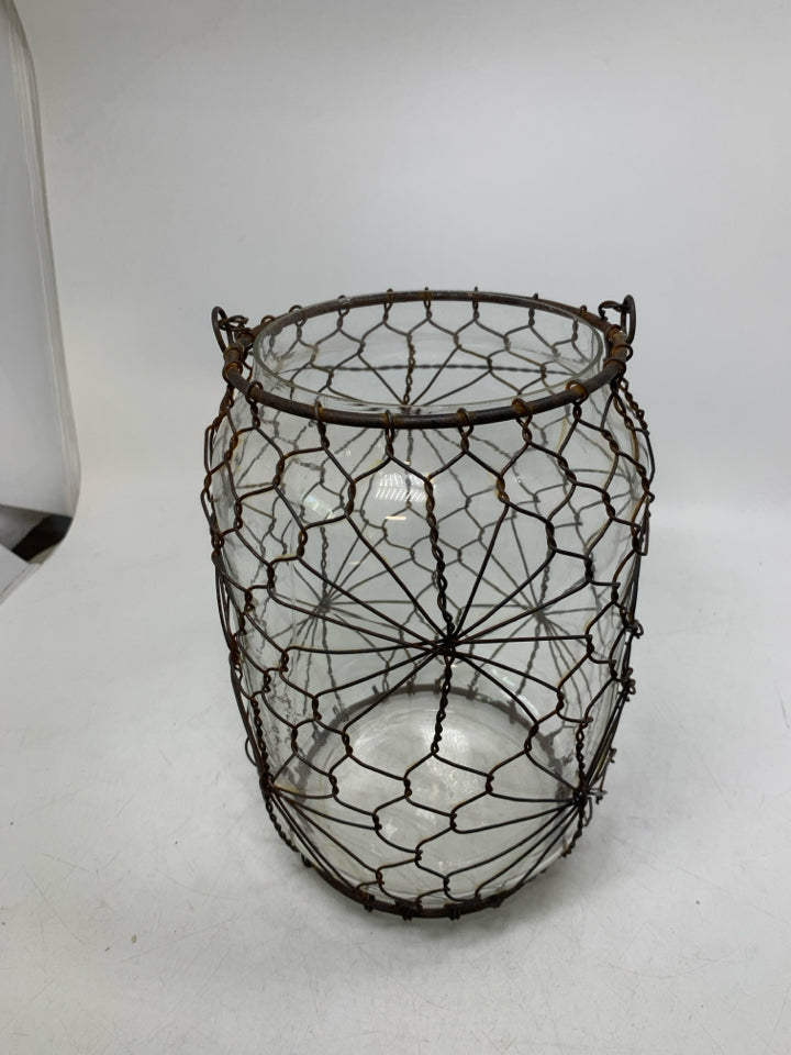 LARGE GLASS JUG W/ RUSTED METAL CAGE HANGING LANTERN.