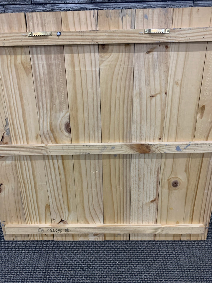 WHITE METAL MEDALLION ON GREY WOOD WALL DECOR.