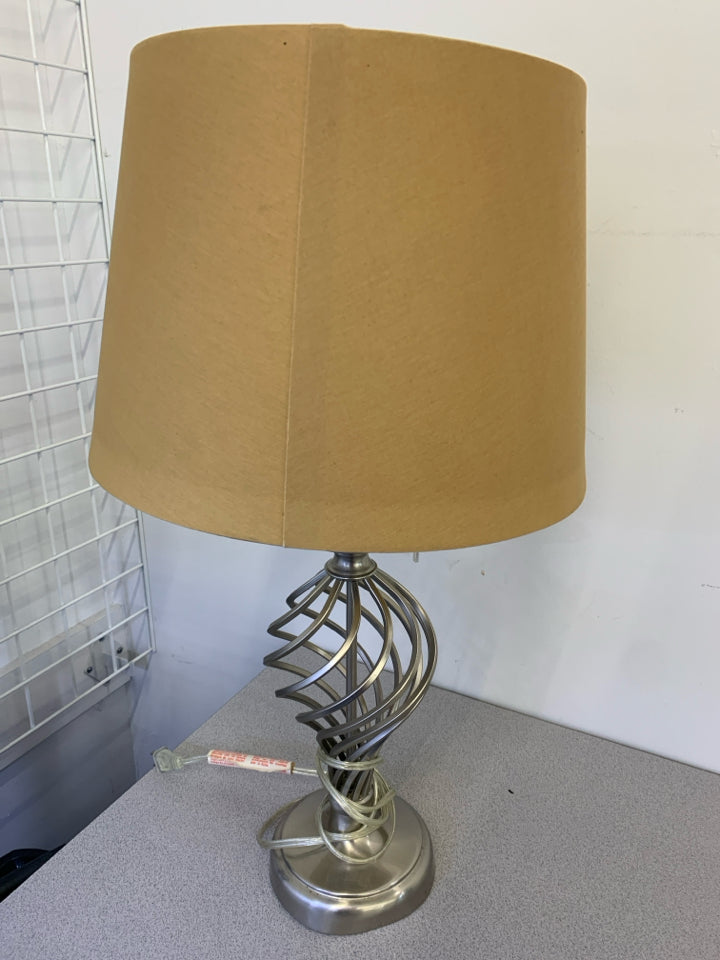 SILVER SWIRL TABLE LAMP WITH TAN SHADE.
