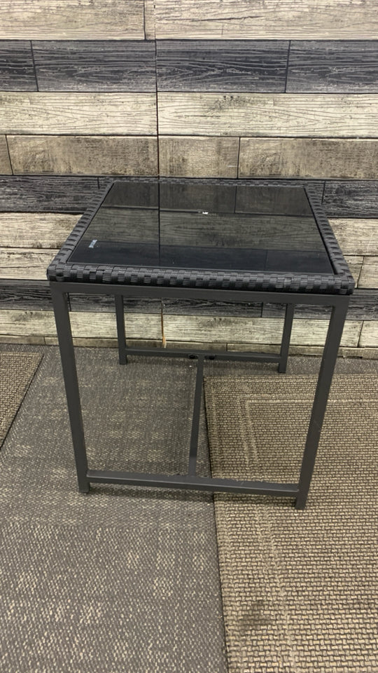 BLACK METAL OUTDOOR SIDE TABLE W/WOVEN EDGE AND TEMPERED GLASS TOP.