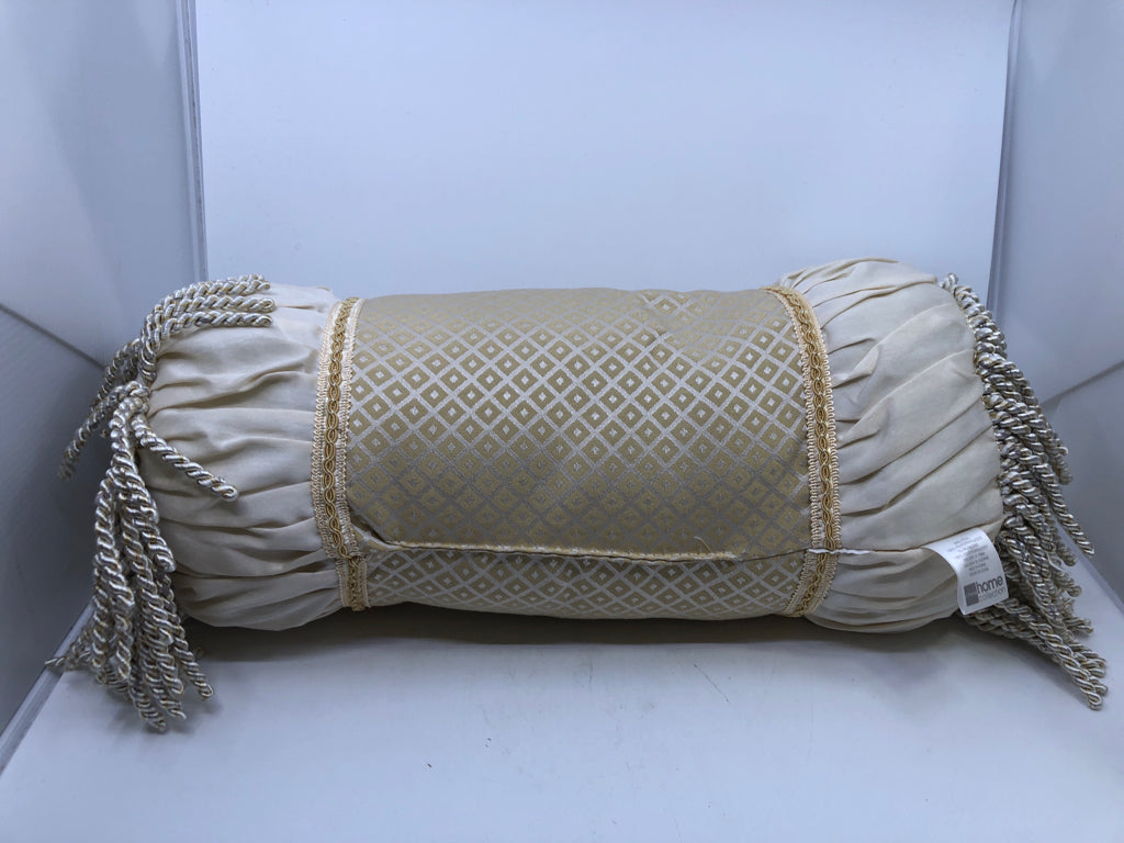 CREAM CYLINDER PILLOW WITH TASSELS.