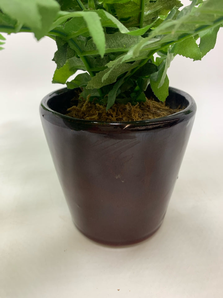 FAUX FERN IN BROWN CERAMIC POT.
