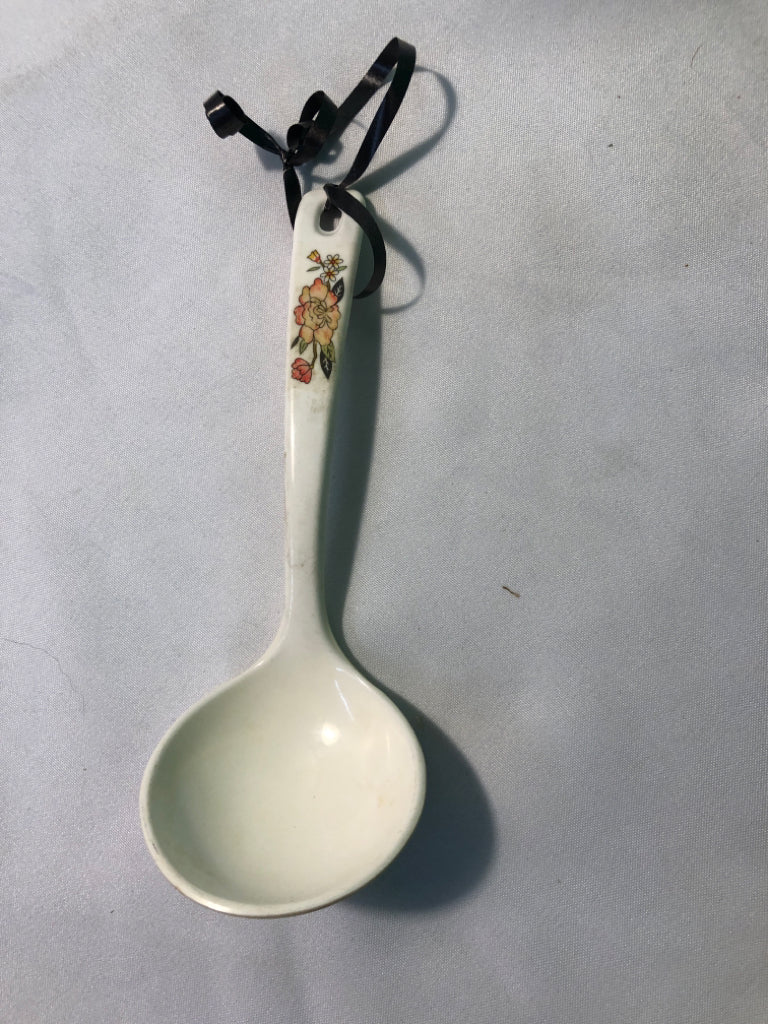 WHITE SERVING SPOON W/ ORANGE FLOWER ON HANDLE.