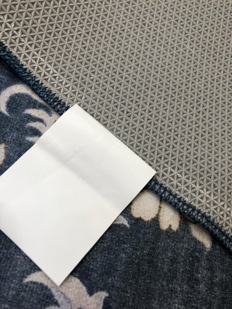 THIN BLUE FLORAL RUG W/YELLOW PETALS.