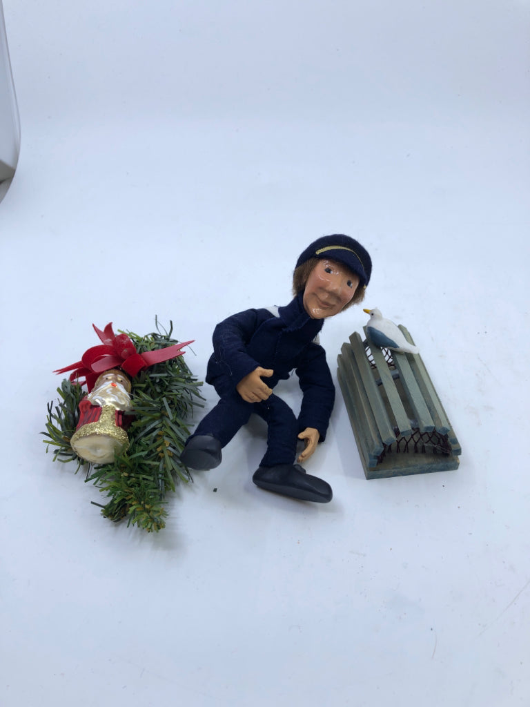 BYERS' CHOICE FISHERMAN SITTING W GARLAND.