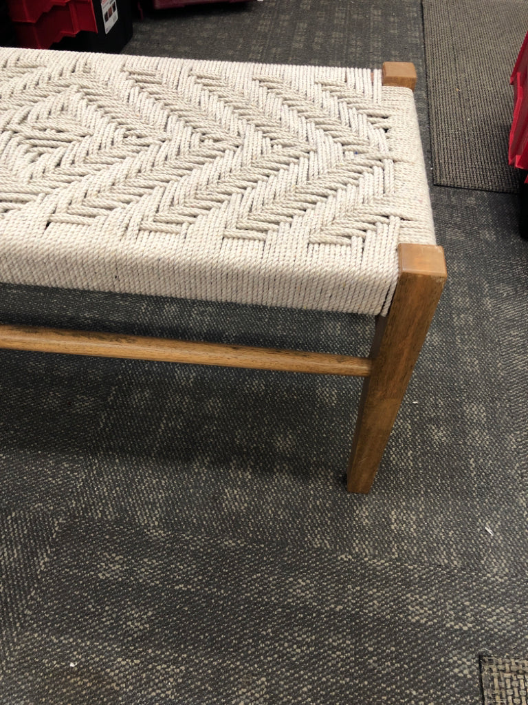 WOOD BENCH WITH GRAY ROPE SEATING.