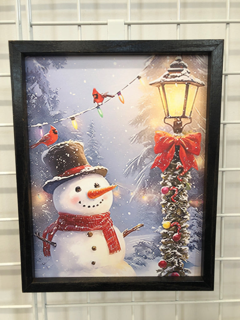 SNOWMAN IN FRONT OF LAMP PRINT IN DRK FRAME.