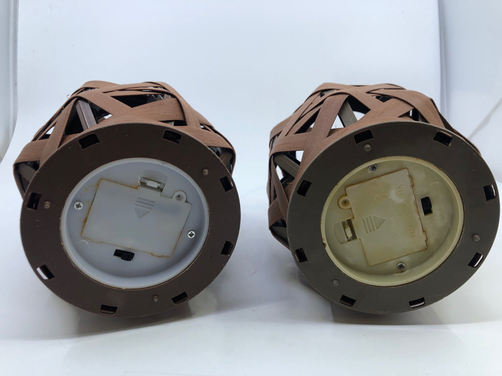 2 BROWN OPEN WEAVE LANTERNS WITH HANDLES AND BATTERY OPERATED CANDLES.