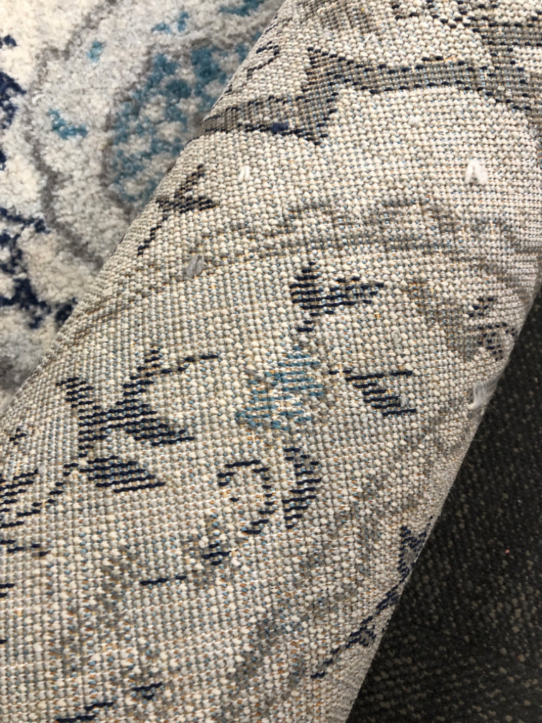 GREY/BLUE ROUND FLORAL RUG.