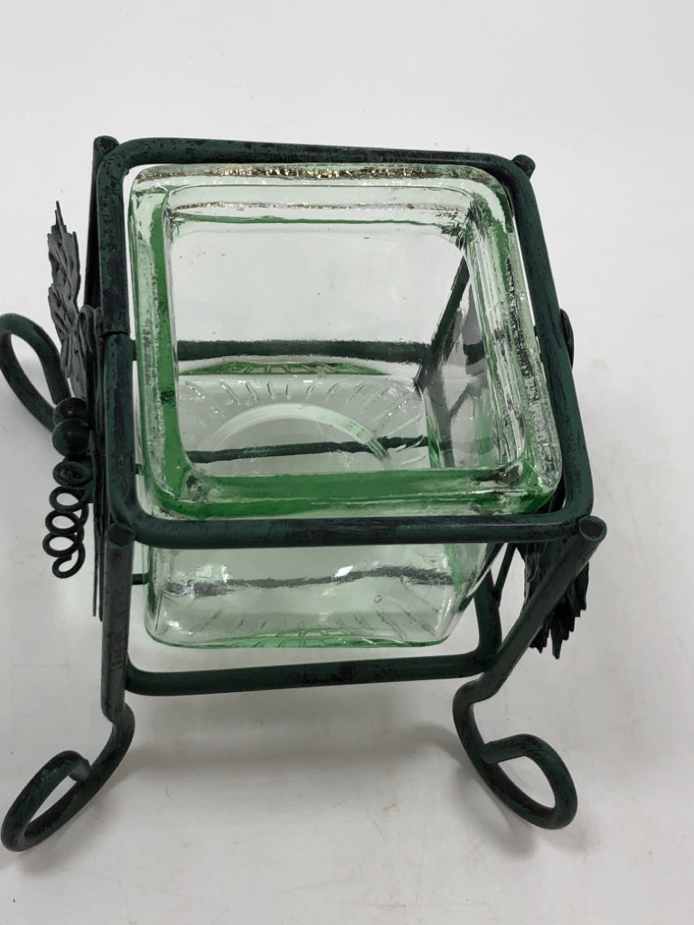 GREEN GLASS VOTIVE HOLDER IN GREEN METAL STAND.