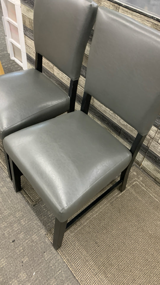 2 GRAY FAUX LEATHER CHAIRS W/BLACK WOOD LEGS.