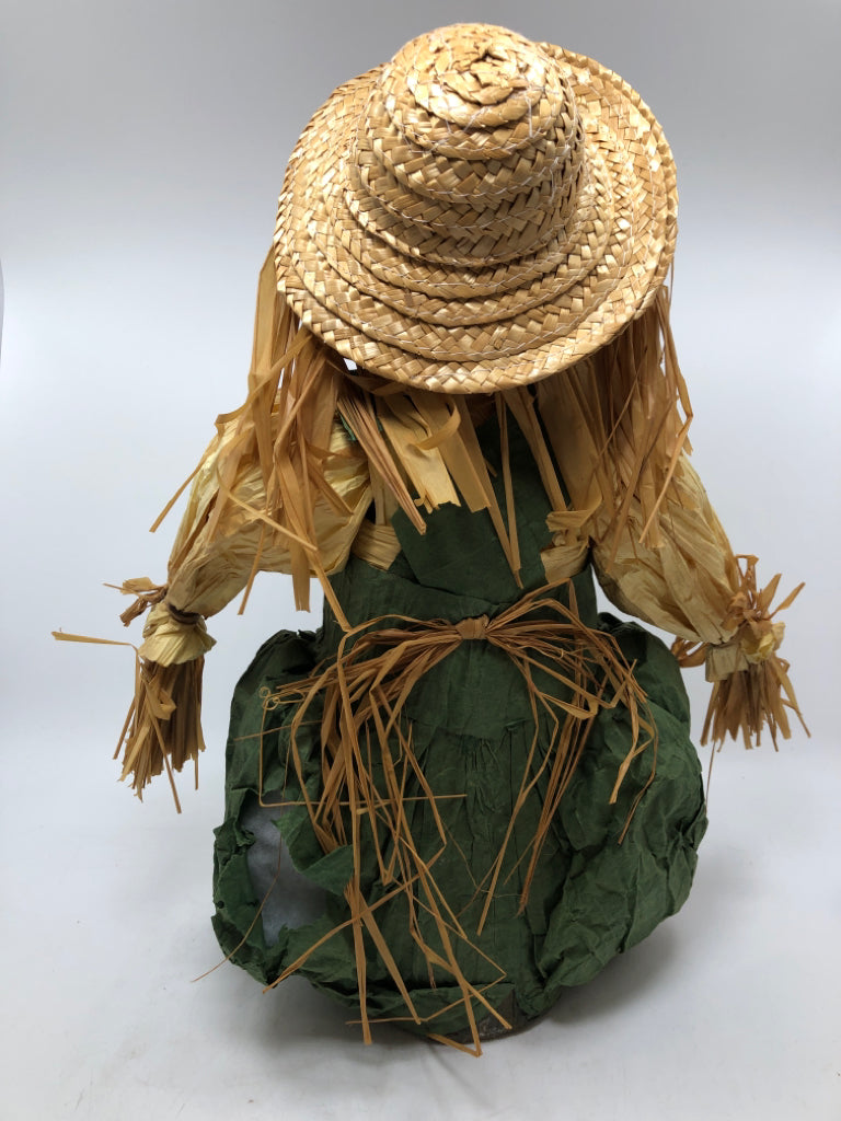 STRAW SCARECROW W/GREEN OVERALLS.