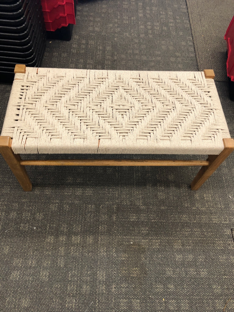 WOOD BENCH WITH GRAY ROPE SEATING.