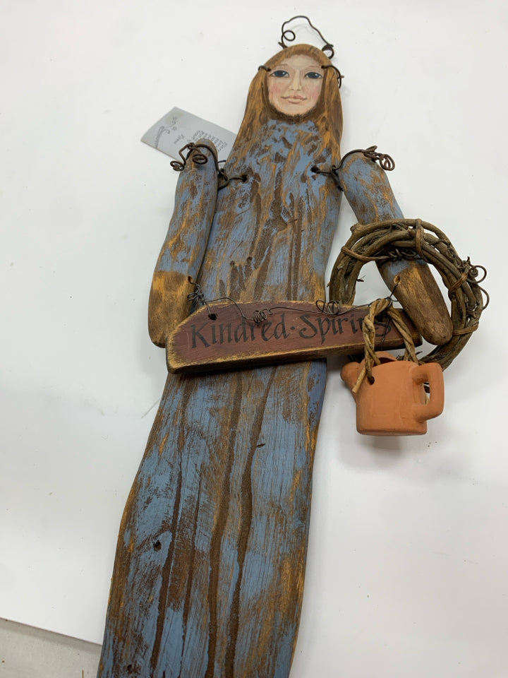 PRIMITIVE WOOD DOLL W WATERING CAN WALL HANGING.