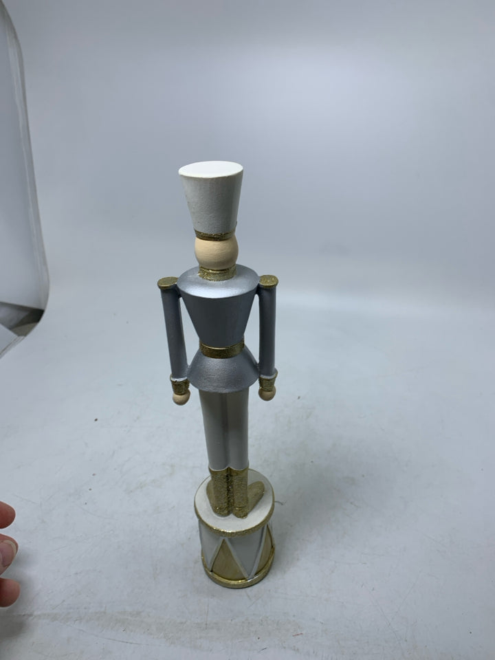 SILVER/GOLD RESIN NUTCRACKER STANDING ON DRUM.