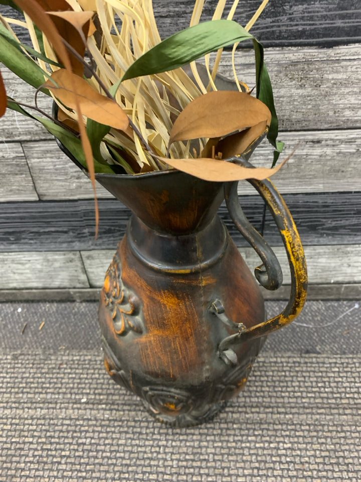LARGE DISTRESSED METAL PITCHER W FAUX LEAVES.