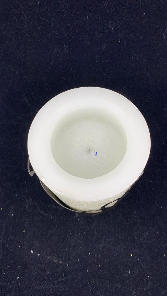 WHITE FAUX LIGHT UP CANDLE IN BROWN LEAF CANDLE HOLDER.