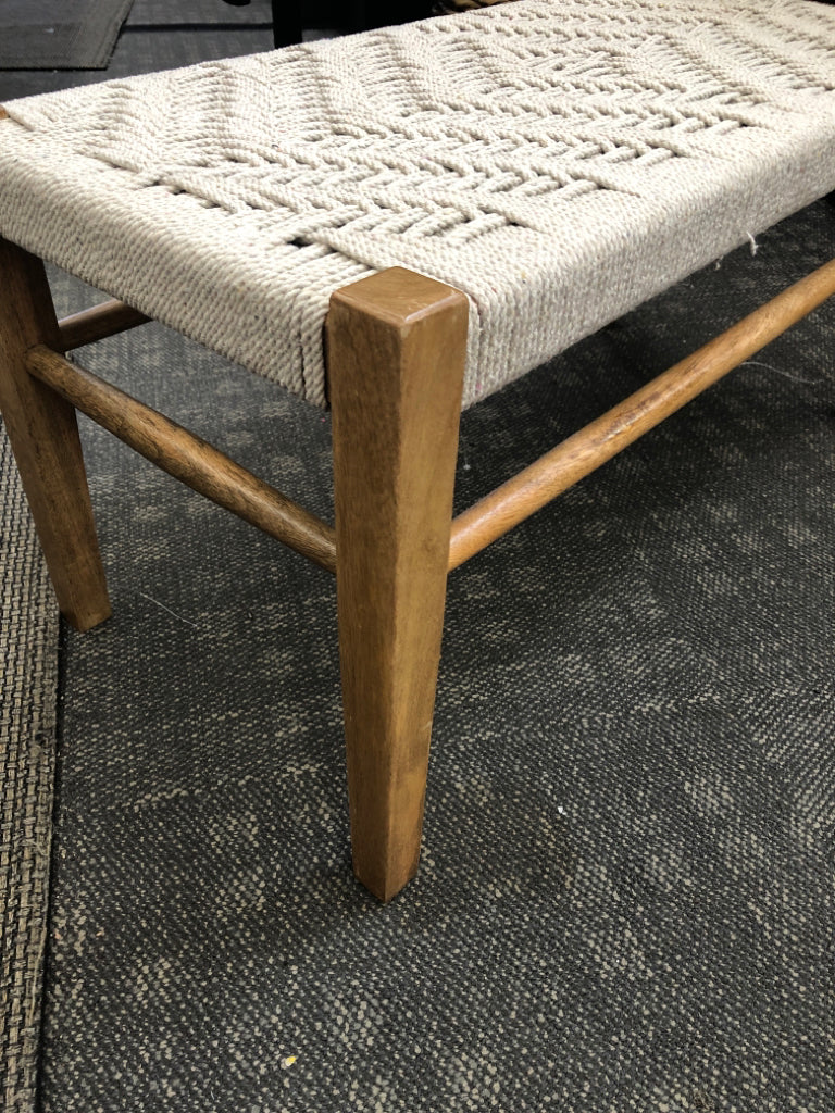 WOOD BENCH WITH GRAY ROPE SEATING.