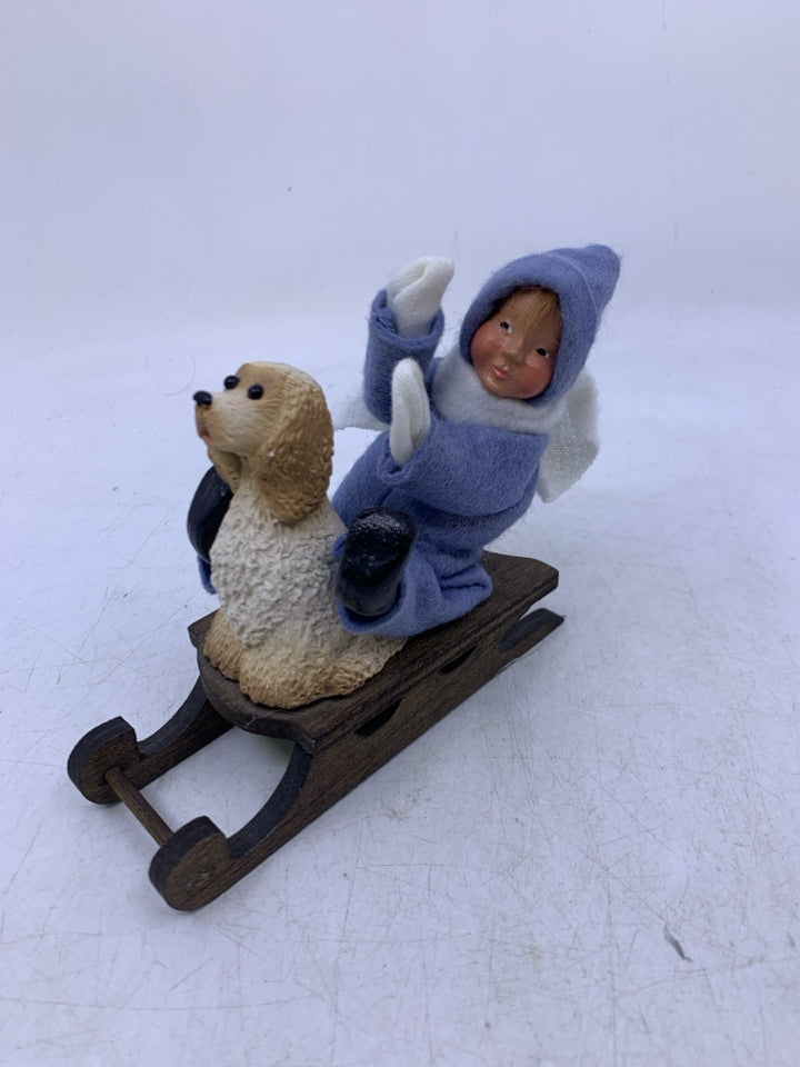 KID IN LIGHT BLUE SUIT ON SLED W/ DOG BYERS' CHOICE 1991.