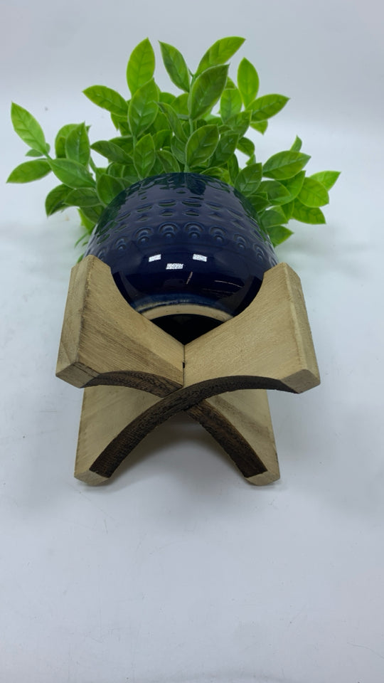 FAUX GREENERY IN BLUE RAISED PLANTER.