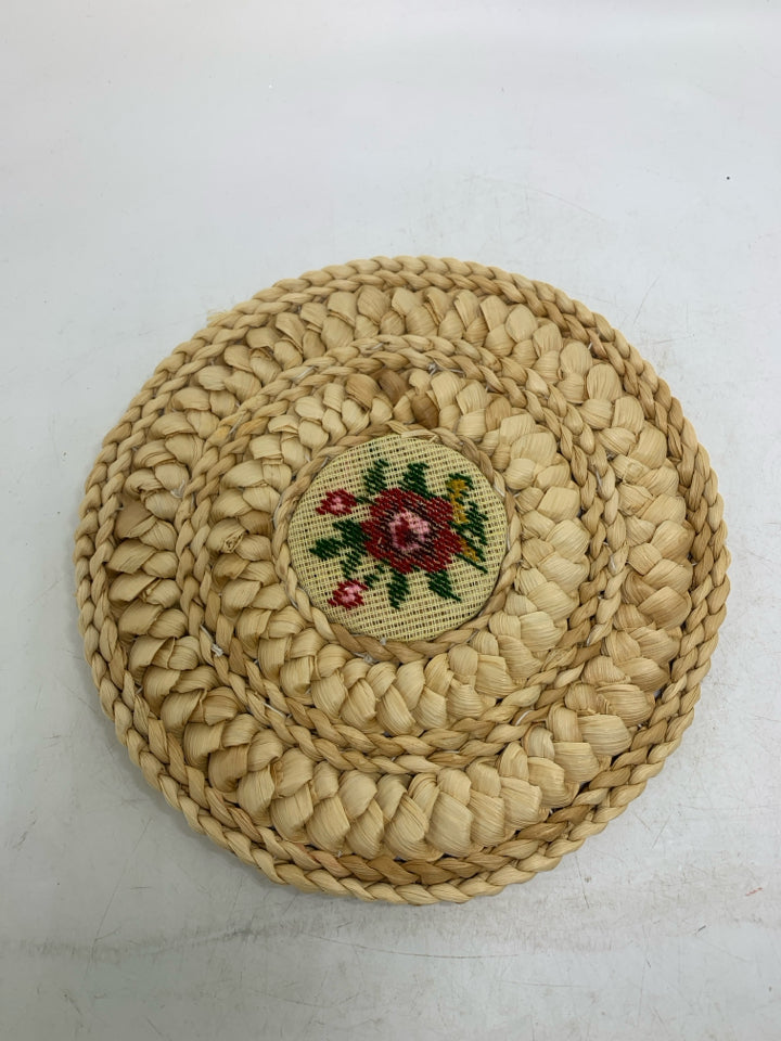 VTG BLONDE WOVEN CIRCLE TRIVET W/ NEEDLE POINT FLORAL CENTER.