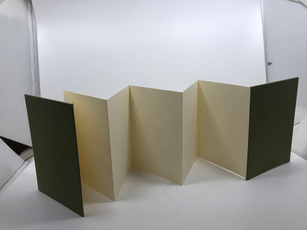 ACCORDION-STYLE GREEN NOTEBOOK.