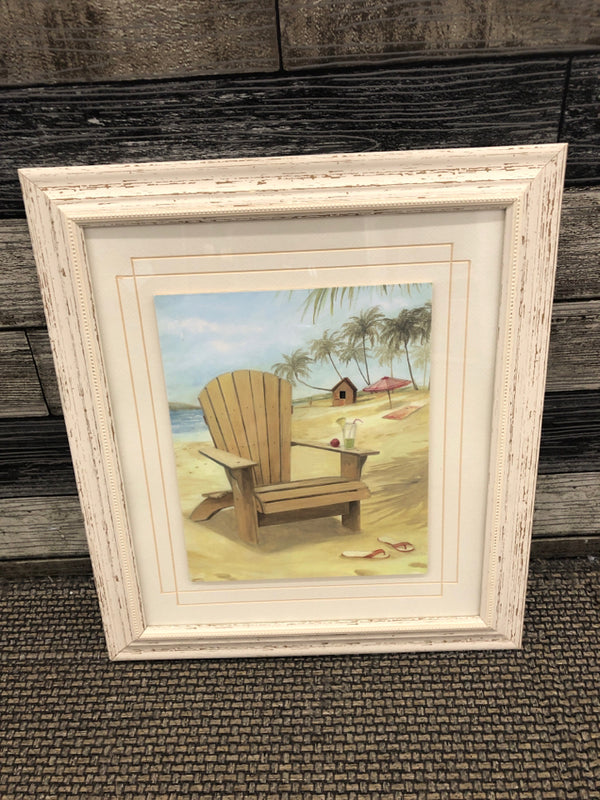 BEACH IN CHAIR IN WHITE DISTRESSED FRAME WALL HANGING.