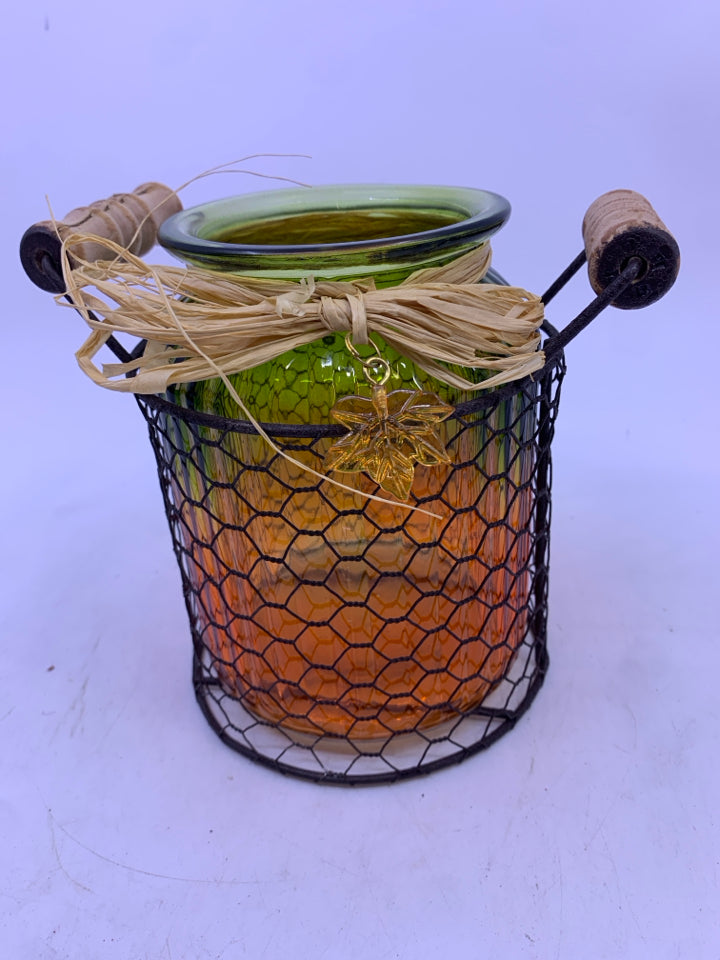 GLASS GREEN/ORANGE RIBBED JAR IN METAL CHICKEN WIRE INSERT CANDLE HOLDER.