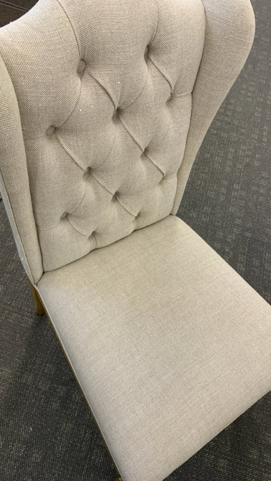 WHITE FABRIC CHAIR W/BROWN WOOD LEGS.