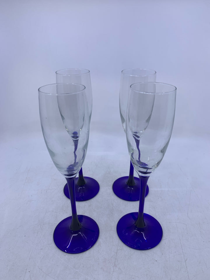 4 CLEAR GLASS CHAMPAGNE FLUTES W/ COBALT BLUE STEMS.