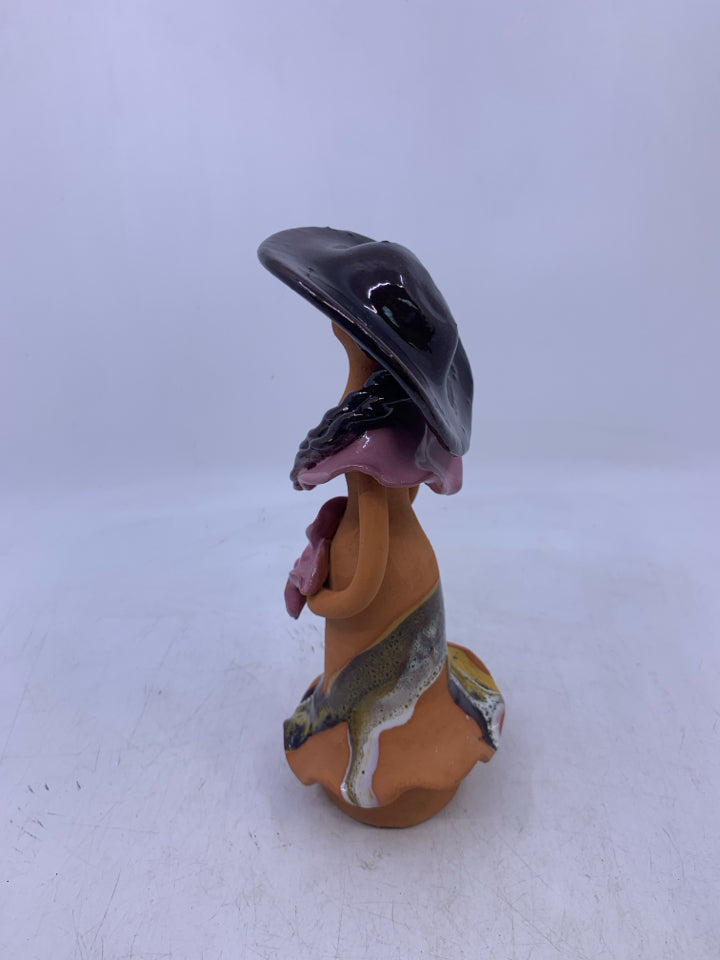 CLAY FACELESS WOMAN BROWN HAT HOLDING PINK FLOWERS.