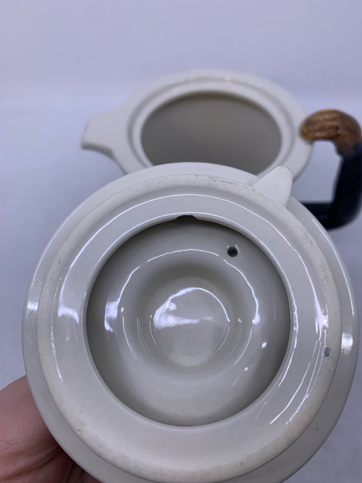 CREAM W/ MONKEY ON IT AND ARM AS HANDLE.