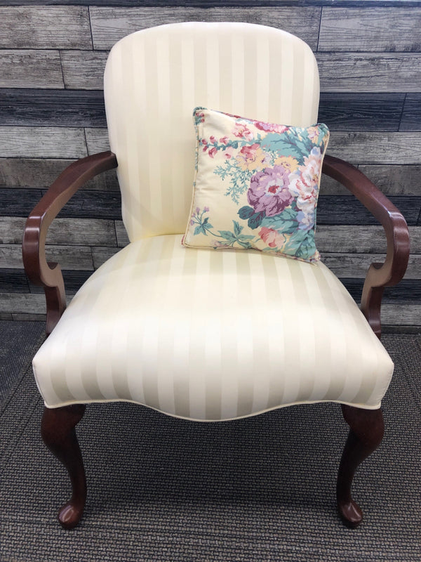 IVORY ARM CHAIR WITH FLOWER PATTERN PILLOW.