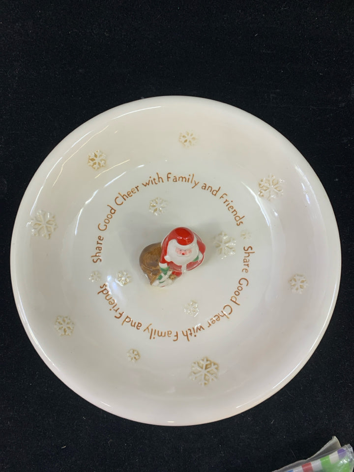 SHARE GOOD CHEER CREAM CERAMIC PLATE WITH RESIN SANTA & TOY BAG IN CENTER.