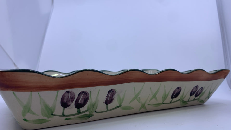 OLIVE CASSEROLE DISH IN METAL HOLDER.
